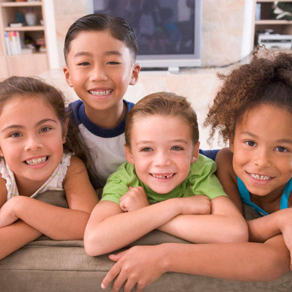 Four kids smiling on a couch