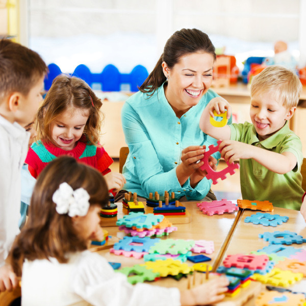 Teacher helping students with puzzle