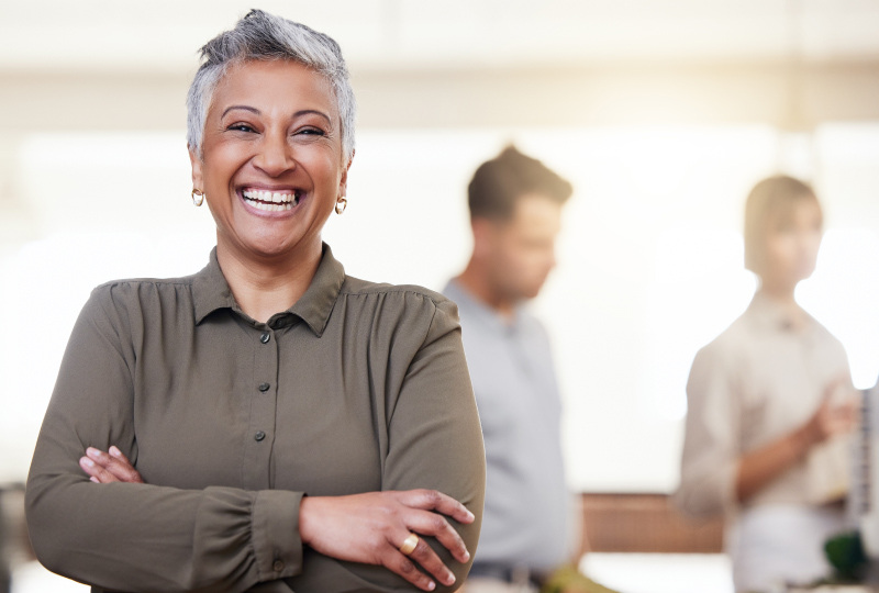 Woman standing facing forward smiling. 