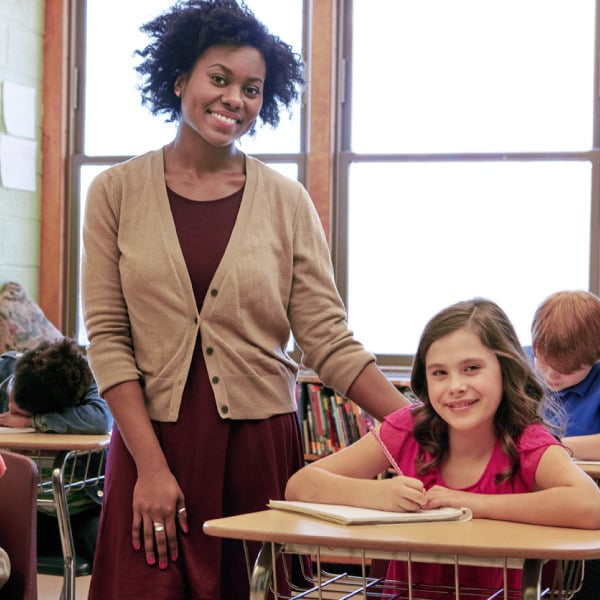 Paraprofessional with student in classroom