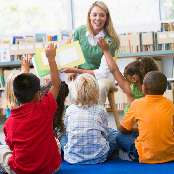 kindergarten teacher reading to children 