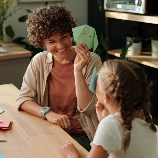 woman and child sitting at kitchen table doing crafts