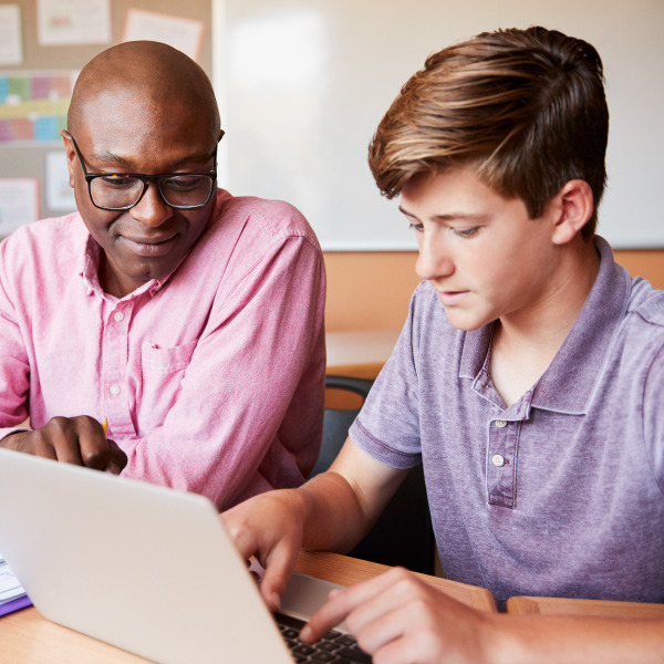 Teacher helping student with computer