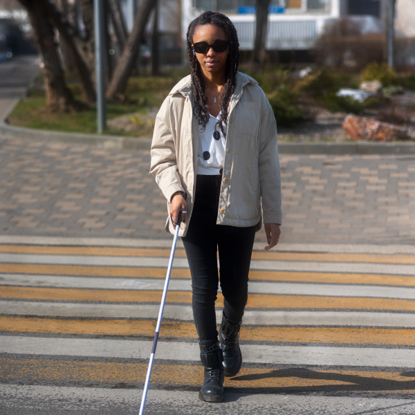 girl standing outside facing forward holding cane