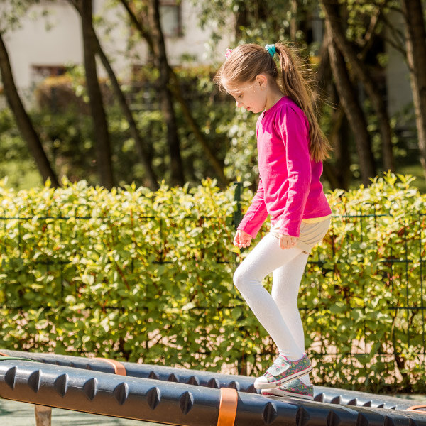 young girl standing on trampoline outside 