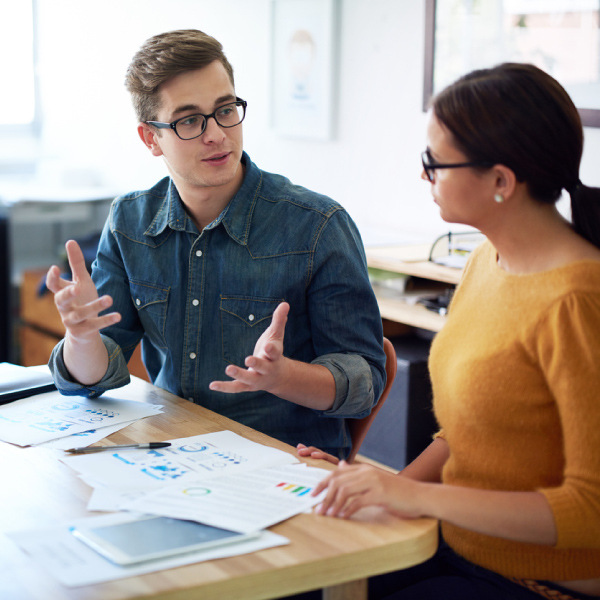 Man and woman talking at desk