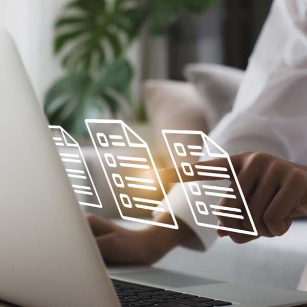 laptop sitting on desk individual pointing at the screen